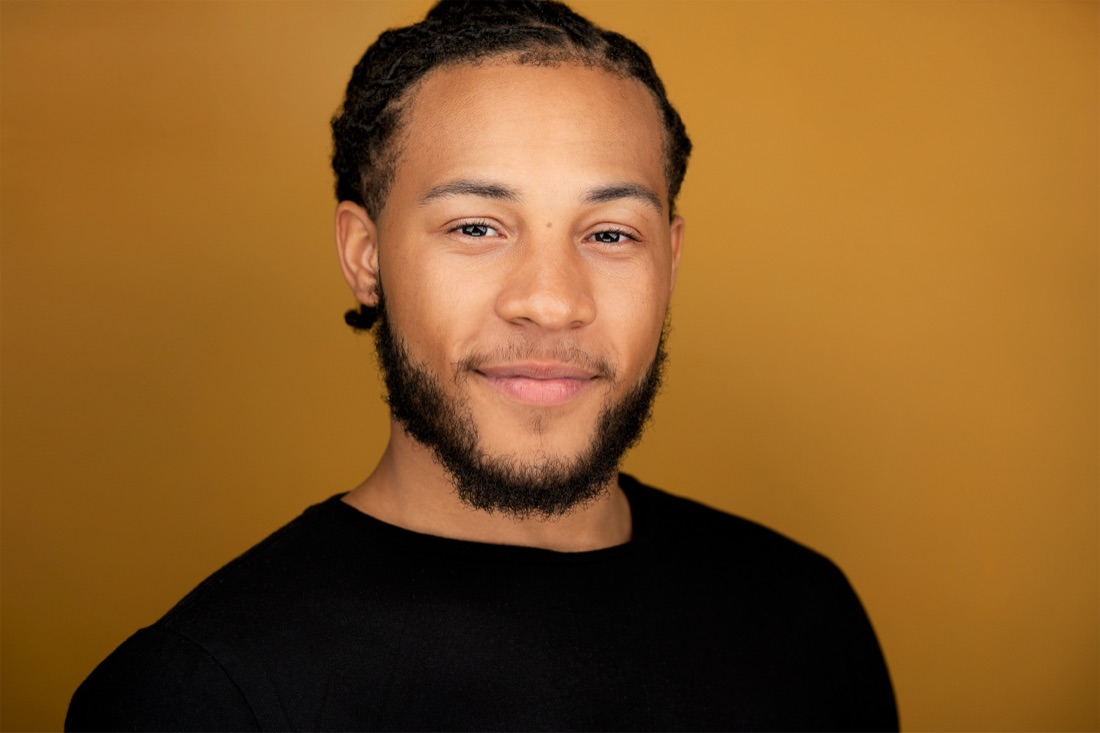 Actor headshot against a gold backdrop