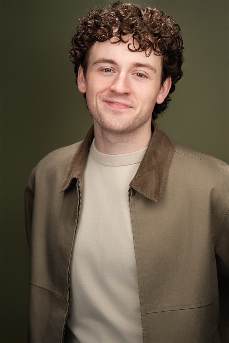 Actor headshot against an olive backdrop
