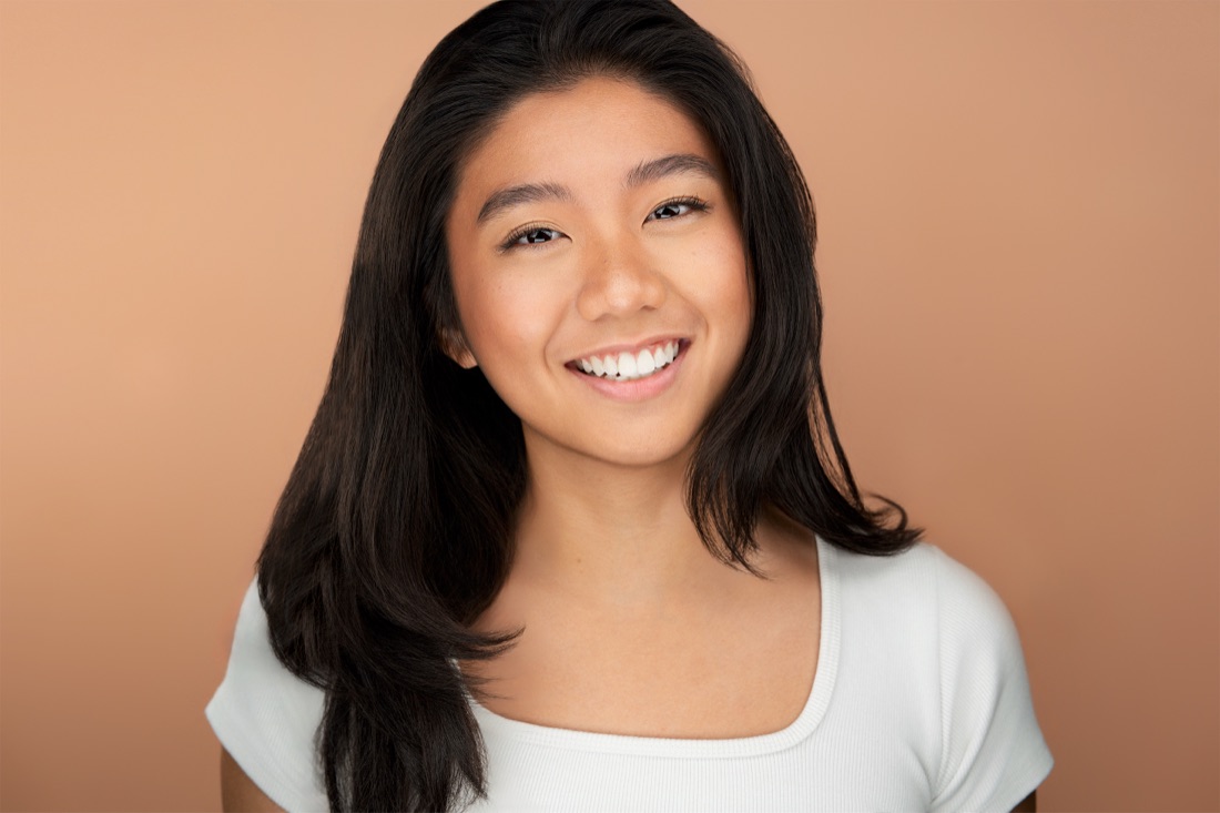 Actor headshot against a peach backdrop